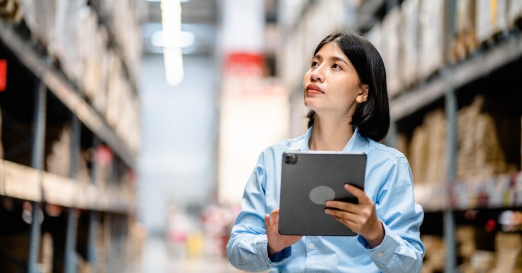 Women warehouse worker using digital tablets to check the stock inventory on shelves in large warehouses