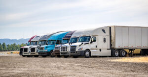 a group of semi trucks and trailers parked next to each other