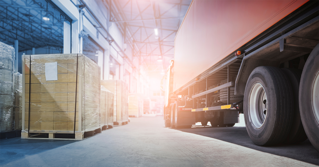 a truck and trailed parked in a warehouse