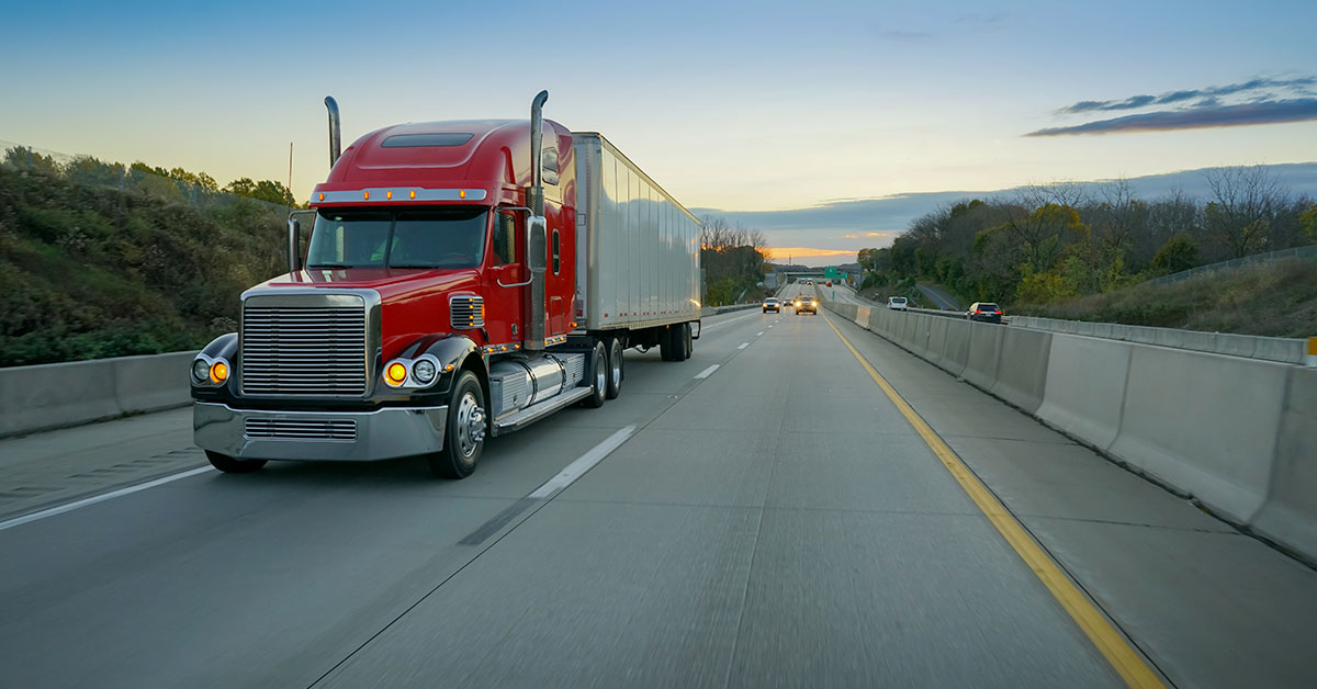 semi truck and trailer driving down the highway