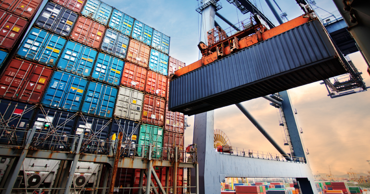 crane moving and stacking cargo shipping containers at a port