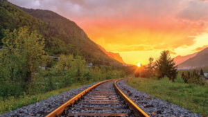 scenic view of railroad tracks with a sunset in the distance