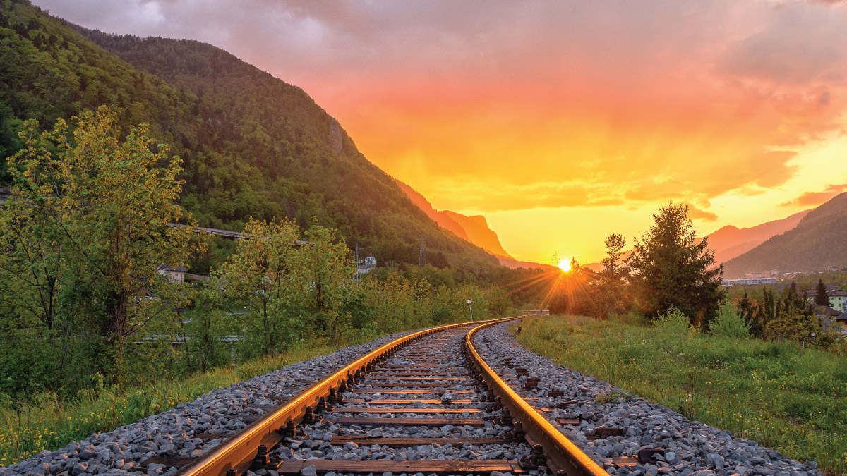 scenic view of railroad tracks with a sunset in the distance