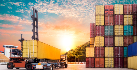 trucks transporting shipping containers in a shipyard