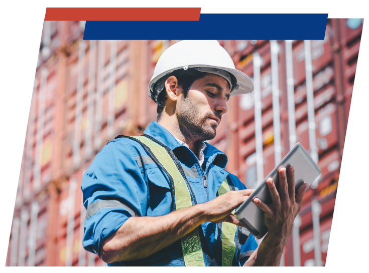 man looking at a tablet surrounded by cargo containers