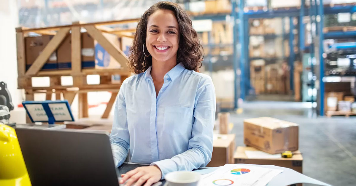 a woman in a warehouse using a laptop