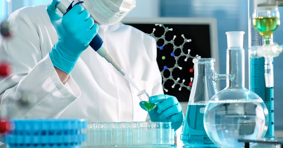 A scientist in a lab holding chemical samples